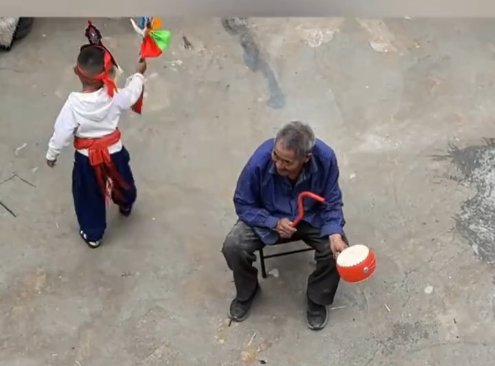 一老一幼表演藏戏，院落里的非遗传承与温情陪伴