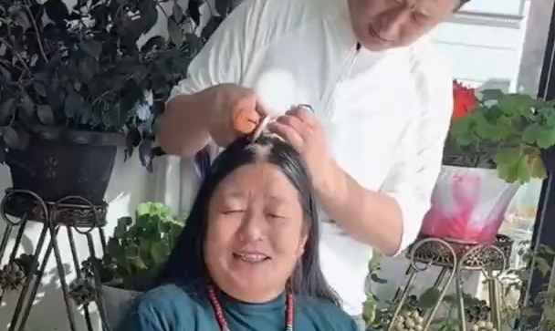 暖阳下儿子为妈妈梳发戴饰