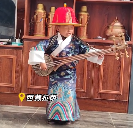 小朋友身着民族服饰弹唱#阿里民歌