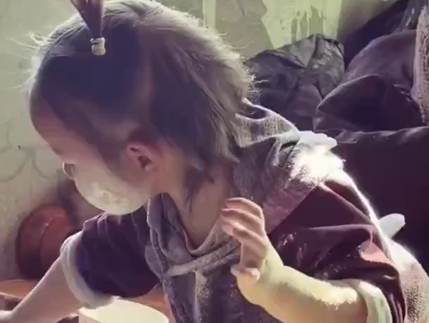 小萌娃用面粉“化妆”，一脸认真的模样