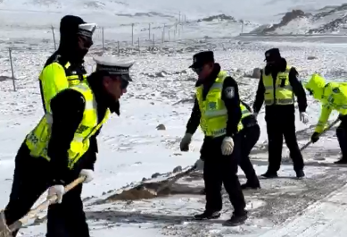 冰雪路上，交警撒沙保障过往车辆通行